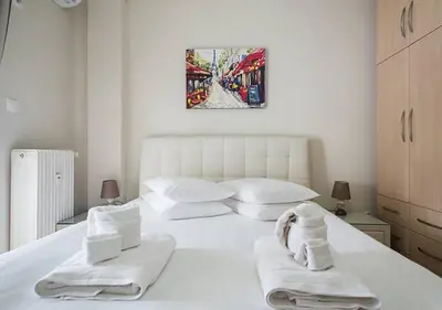 a bedroom with a white bed with towels on it at MEDLUXE EASY ACROPOLIS APARTMENT! in Athens