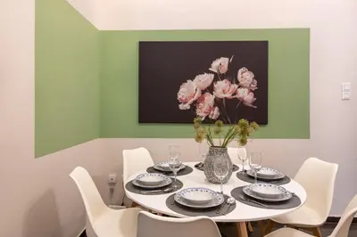 a dining room with a table with a vase of flowers at MEDLUXE LUXURY APARTMENT ! in Athens