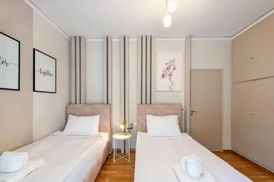 two beds in a room with white walls at MEDLUXE LUXURY APARTMENT ! in Athens