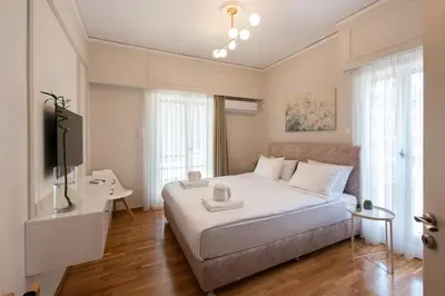 a bedroom with a white bed and a television at MEDLUXE LUXURY APARTMENT ! in Athens