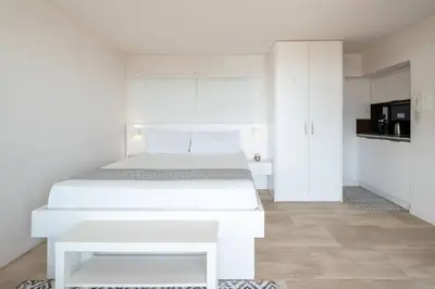 a white bedroom with a white bed and white cabinets at Athens Riviera Bay View Suite By The Olon in Athens