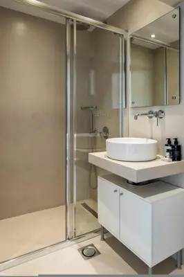 a white bathroom with a sink and a shower at Athens Riviera Bay View Suite By The Olon in Athens
