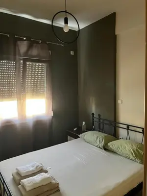 a bedroom with a bed with two towels on it at Πάρκο Γουδή in Athens