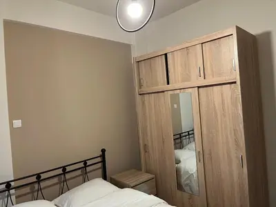 a bedroom with a wooden cabinet and a bed at Πάρκο Γουδή in Athens