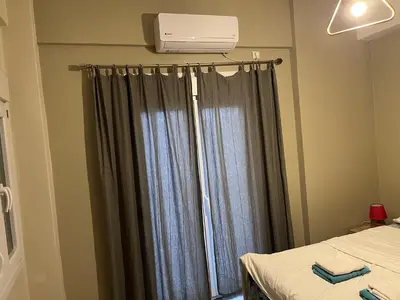 a bedroom with a window with a air conditioner at Πάρκο Γουδή in Athens