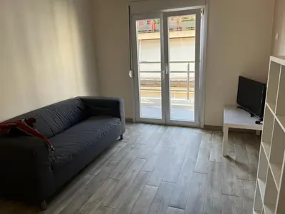 a living room with a couch and a television at Πάρκο Γουδή in Athens