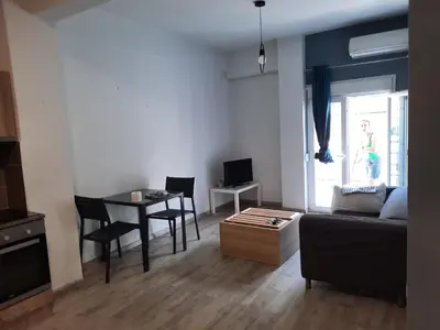 a living room with a couch and a table at Πάρκο Γουδή in Athens