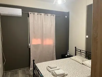 a bedroom with two beds and a window with towels at Πάρκο Γουδή in Athens