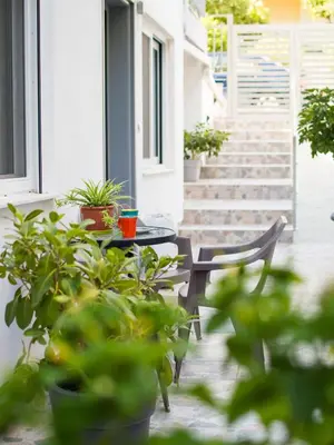 a patio with a table and chairs and potted plants at Easy & Comfy Nights in Athens
