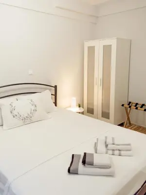 a bedroom with a white bed with two towels on it at Easy & Comfy Nights in Athens
