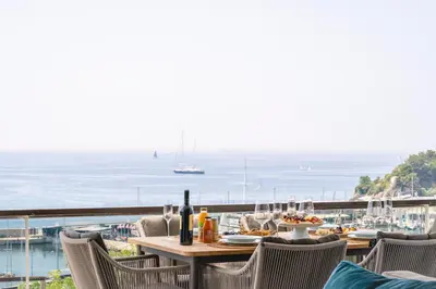 a table and chairs with a view of the ocean at Divine Residence, a SeaView Retreat, By ThinkVilla in Piraeus