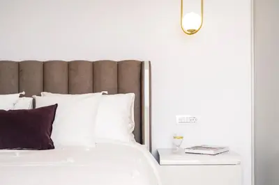 a bedroom with a white bed with a brown headboard at Divine Residence, a SeaView Retreat, By ThinkVilla in Piraeus