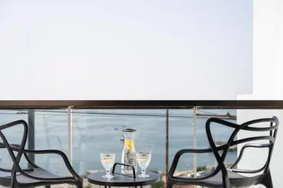 two chairs and a table with glasses on it at Divine Residence, a SeaView Retreat, By ThinkVilla in Piraeus