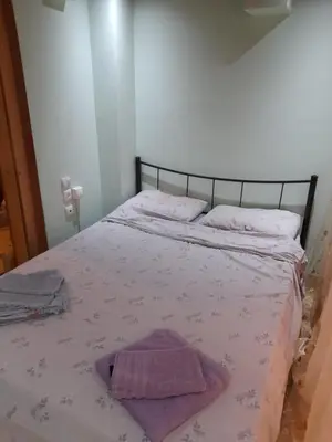 a bedroom with a bed with a purple towel on it at Cozy apartment in Piraeus