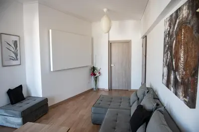 a living room with a couch and a chair at Renovated apartment 5min from subway station 'Attiki' in Athens