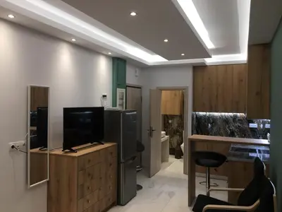 a living room with a television and a kitchen at LUXURY IPOGA in Athens