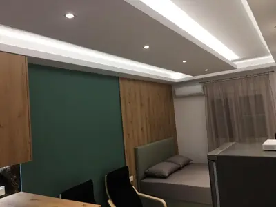 a room with a green wall and a table and chairs at LUXURY IPOGA in Athens
