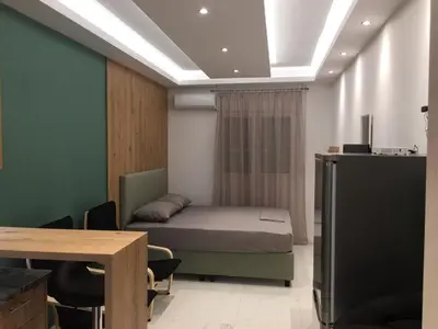 a bedroom with a bed and a table and a tv at LUXURY IPOGA in Athens