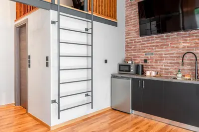a kitchen with a counter and a brick wall at Industrial Rental Loft in Athens