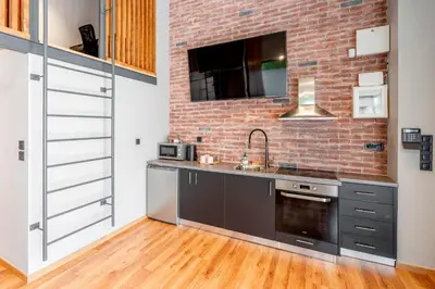 a kitchen with a sink and a brick wall at Industrial Rental Loft in Athens
