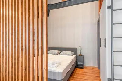 a bedroom with a bed and a wooden wall at Industrial Rental Loft in Athens