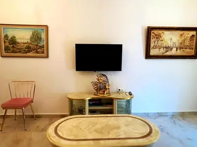 a living room with a tv and a table and a chair at Apollonion Luxury Apartment near the metro station in Athens