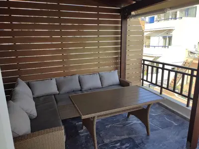 a couch and a table on a balcony at Blue Seaview Suites in Piraeus