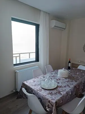 a dining room with a table and chairs and a window at Blue Seaview Suites in Piraeus
