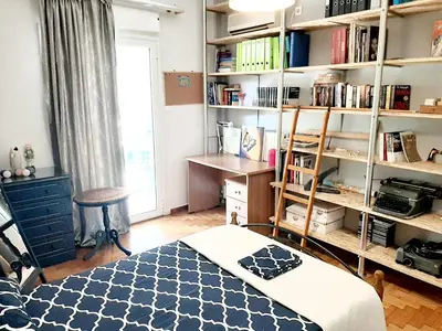 a bedroom with a bed and a book shelf at Large terrace apartment near city centre in Athens