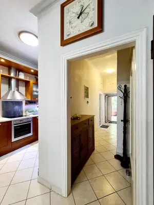 a large kitchen with a clock on the wall at Large terrace apartment near city centre in Athens