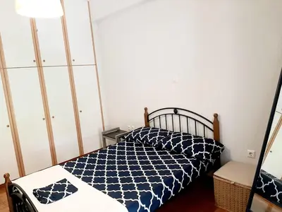 a bedroom with a bed with a blue and white comforter at Large terrace apartment near city centre in Athens