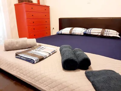 a bed with two pillows and towels on it at Large terrace apartment near city centre in Athens