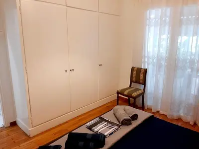 a living room with a chair and a table at Large terrace apartment near city centre in Athens