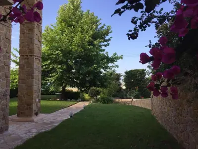 a garden with a stone fence and purple flowers at Platanus Gardenhouse in Anavissos