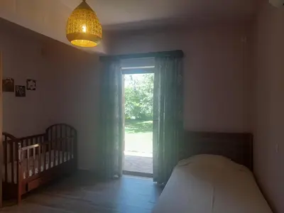 a bedroom with a bed and a window and a crib at Platanus Gardenhouse in Anavissos