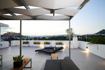 a rooftop patio with couches and tables on a building at Ma Maison No7 Acropolis View Mansion, Roof Garden in Athens