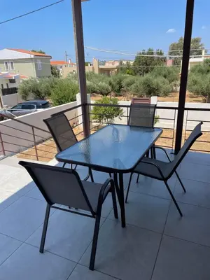 a blue table and chairs on a balcony with a view at Saint George family house in Palaiá Fókaia