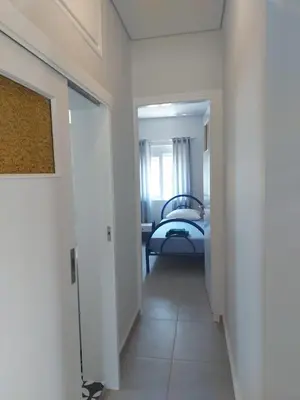 a hallway leading to a bedroom with a bed at Saint George family house in Palaiá Fókaia