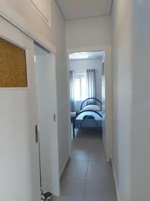 a hallway leading to a bedroom with a bed in it at Saint George family house in Palaiá Fókaia