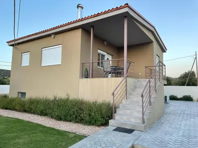 a house with a staircase in front of it at Saint George family house in Palaiá Fókaia