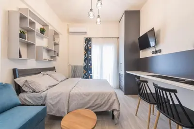 a bedroom with a bed and a kitchen in a room at ANO PATISIA STUDIO (ΑΓΙΟΣ ΕΛΕΥΘΕΡΙΟΣ) in Athens