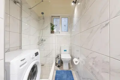 a white bathroom with a washing machine in it at ANO PATISIA STUDIO (ΑΓΙΟΣ ΕΛΕΥΘΕΡΙΟΣ) in Athens