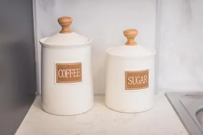 a couple of white containers sitting on a counter at ANO PATISIA STUDIO (ΑΓΙΟΣ ΕΛΕΥΘΕΡΙΟΣ) in Athens