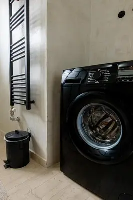 a washing machine in a room with a trash can at Skyhi Athens Penthouse ! in Athens