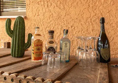 a group of bottles and glasses on a wooden table at Skyhi Athens Penthouse ! in Athens