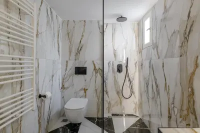 a bathroom with a toilet and a glass shower at Meno Suite with Private Terrace - Jaccuzzi, Acropolis View in Athens
