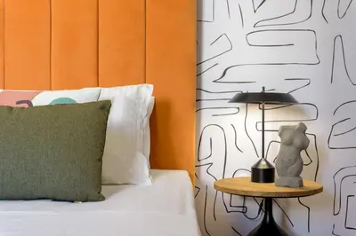 a bed with a side table with a lamp on it at Meno Suite with Private Terrace - Jaccuzzi, Acropolis View in Athens
