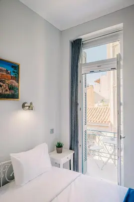 a bedroom with a bed and a window at Neapolis 1897 Boutique Luxury Rooms in Athens