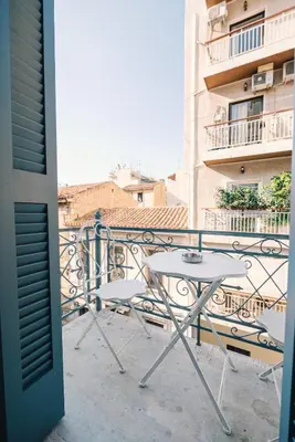 a table and chairs on the balcony of a building at Neapolis 1897 Boutique Luxury Rooms in Athens