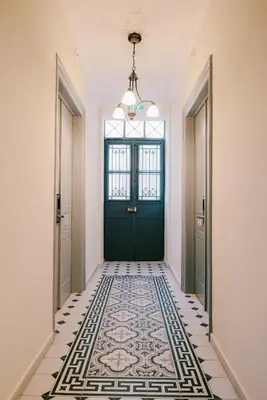 a hallway with a green door and a tile floor at Neapolis 1897 Boutique Luxury Rooms in Athens